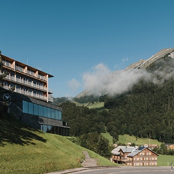 Exterior view of Hotel Adler with the Kanisfluh and houses in the background.